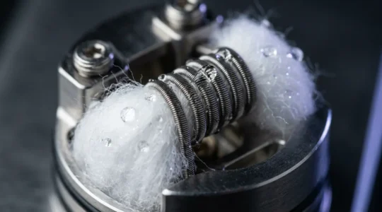 Vue macro détaillée d'une résistance de cigarette électronique montrant les fibres de coton et le fil résistif
